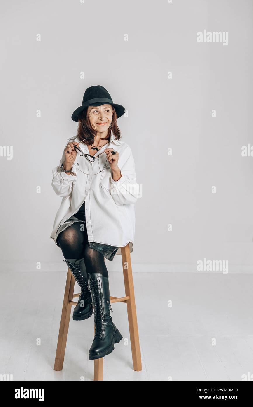 Senior woman sitting on stool hi-res stock photography and images - Alamy
