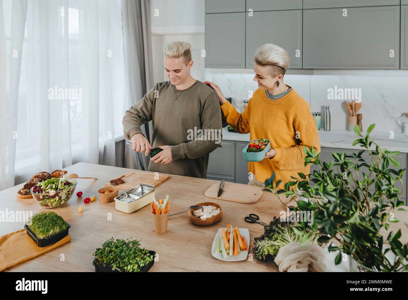 Happy couple preparing healthy food for lunch boxes Stock Photo