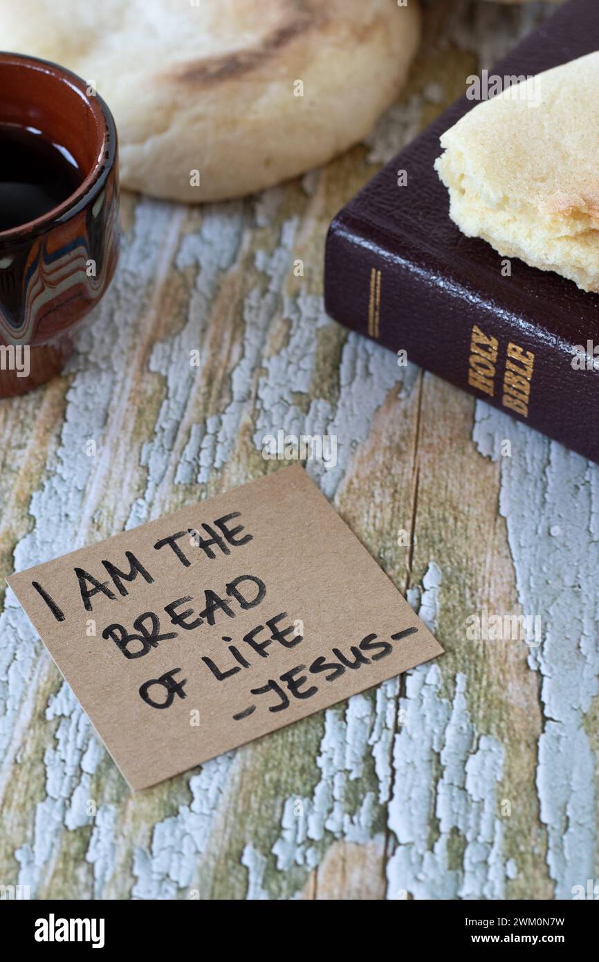 I am the bread of life-Jesus Christ, handwritten text with holy bible book and cup of wine. Christian Passover, spiritual food and drink concept. Stock Photo