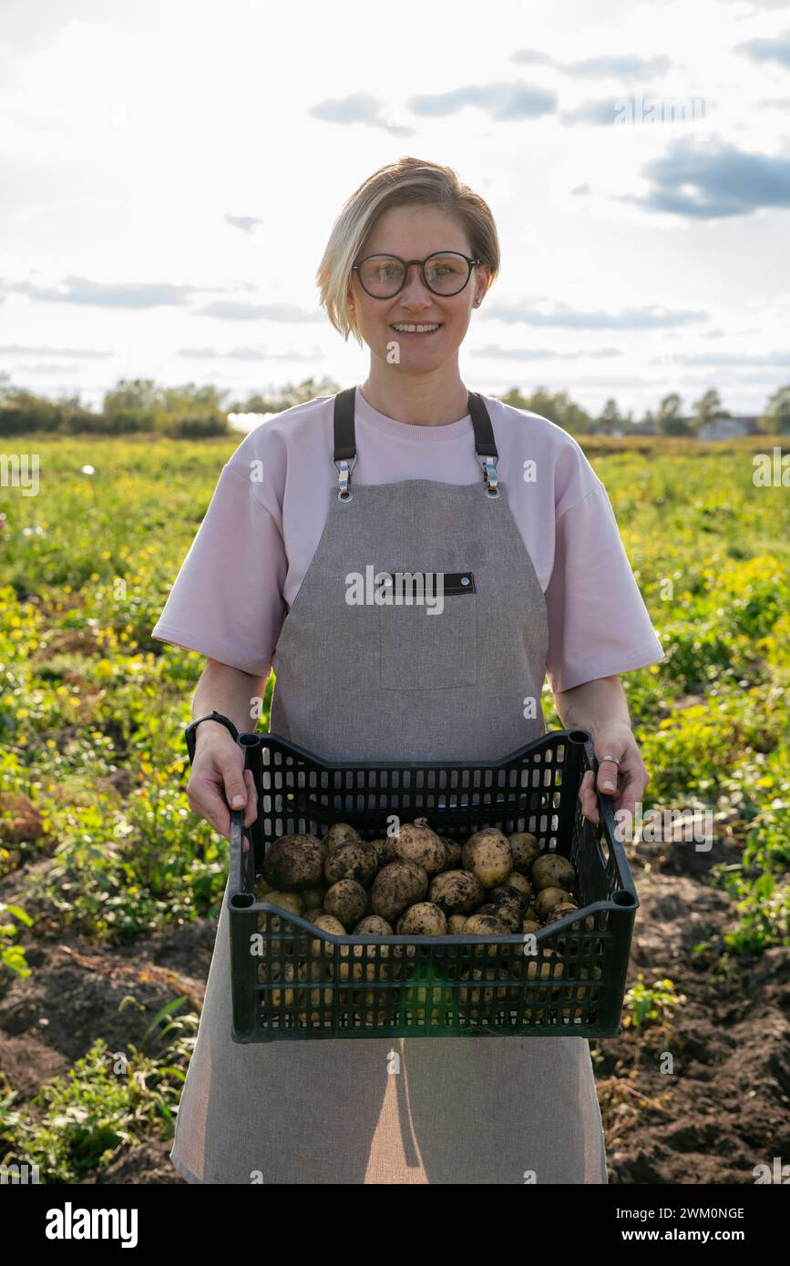 Smiling farmer holding crate of potatoes in farm Stock Photo - Alamy