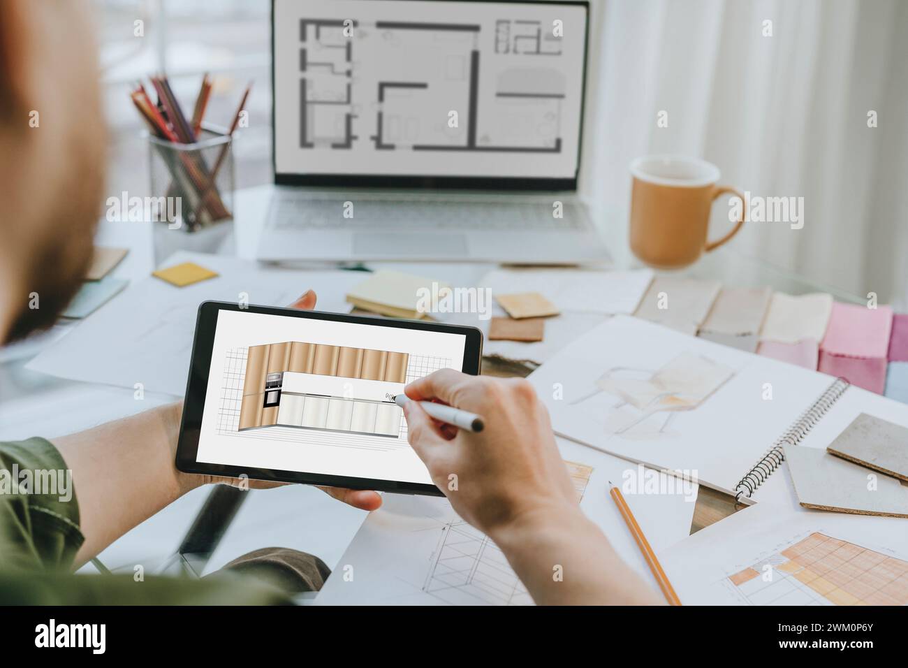 Interior designer drawing kitchen design on tablet PC at office Stock Photo