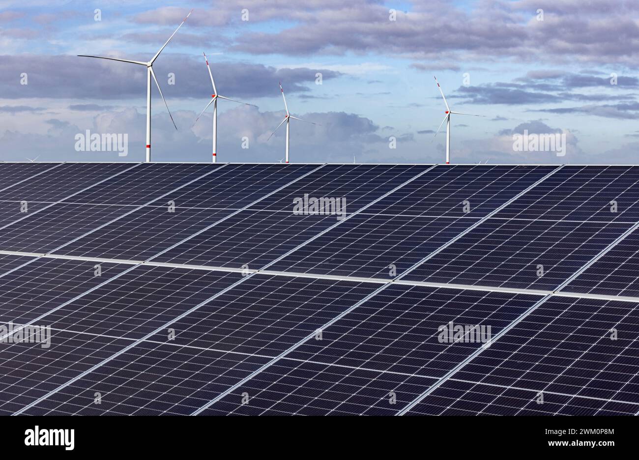 Solar power station with wind farm in background Stock Photo - Alamy