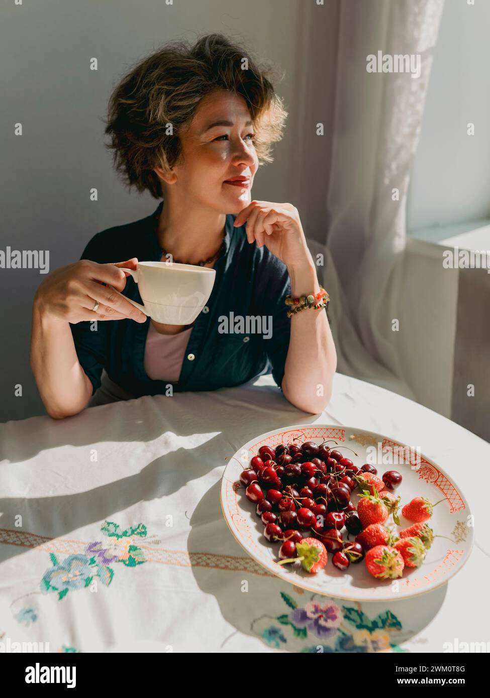 Woman Having Tea Mature woman having tea and berries at home Stock Photo - Alamy