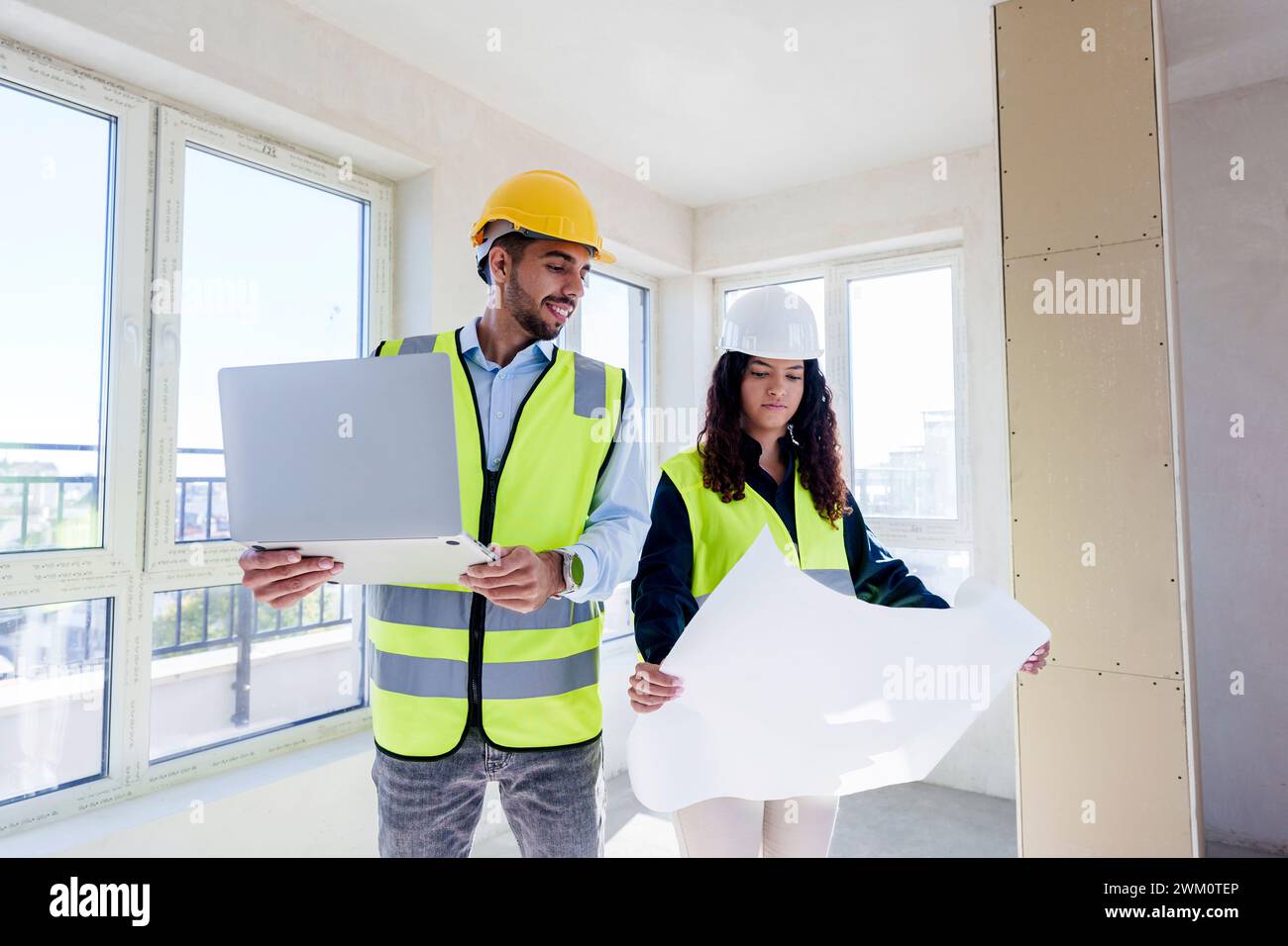 Architects discussing over blueprint at site Stock Photo