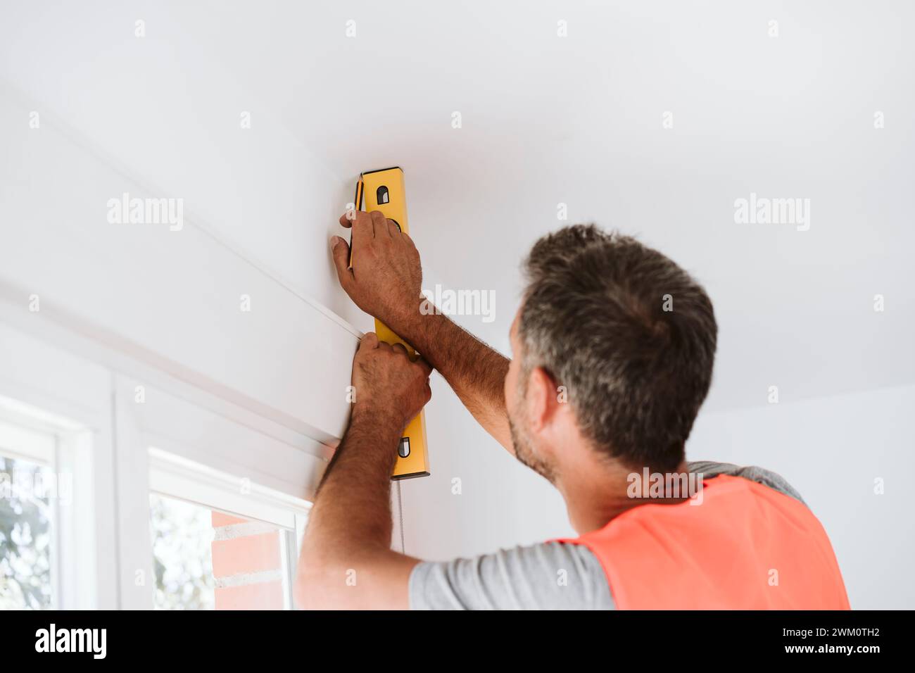 Repairman using leveling tool at house under renovation Stock Photo