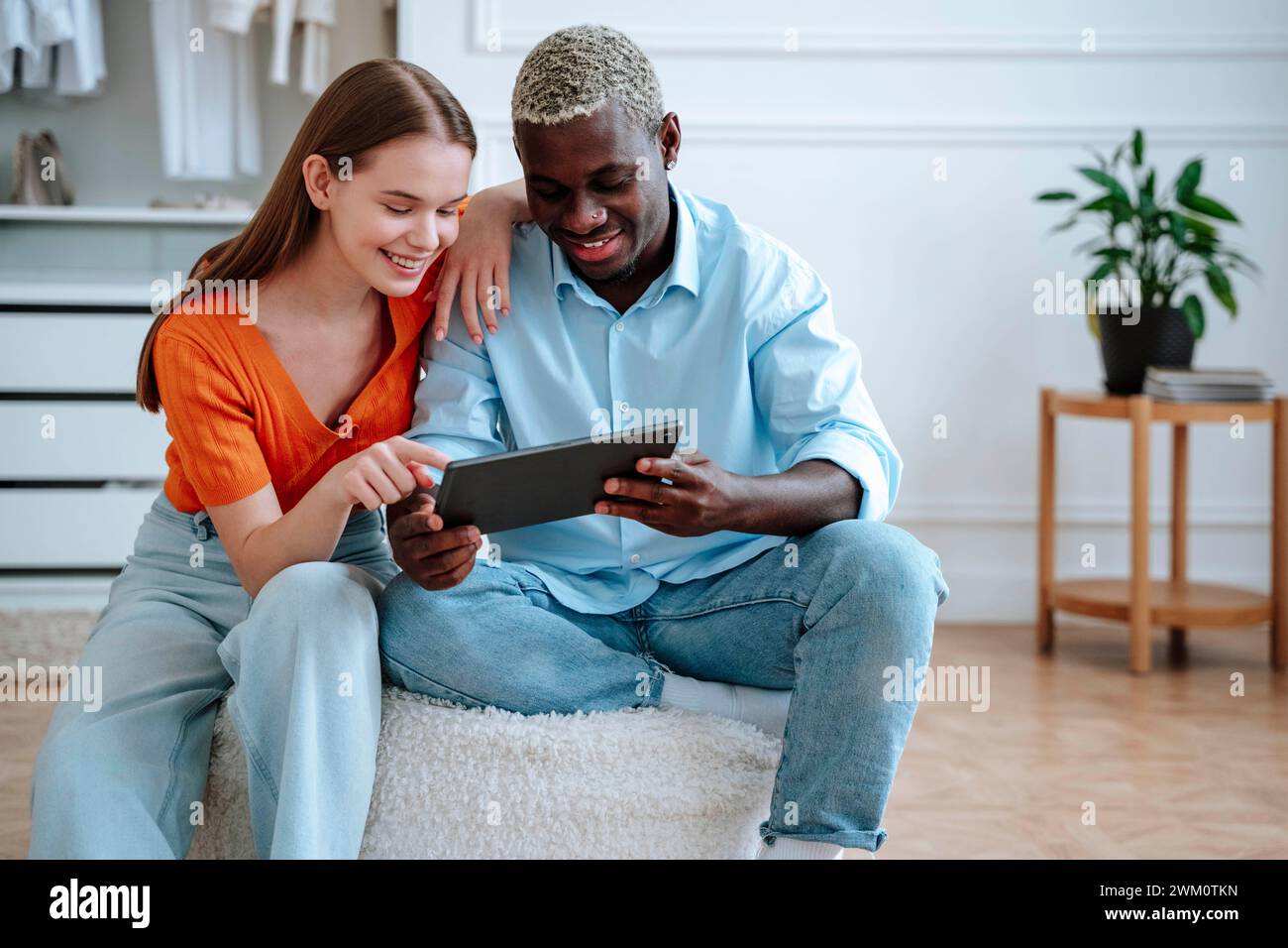 Happy young couple using tablet PC at home Stock Photo