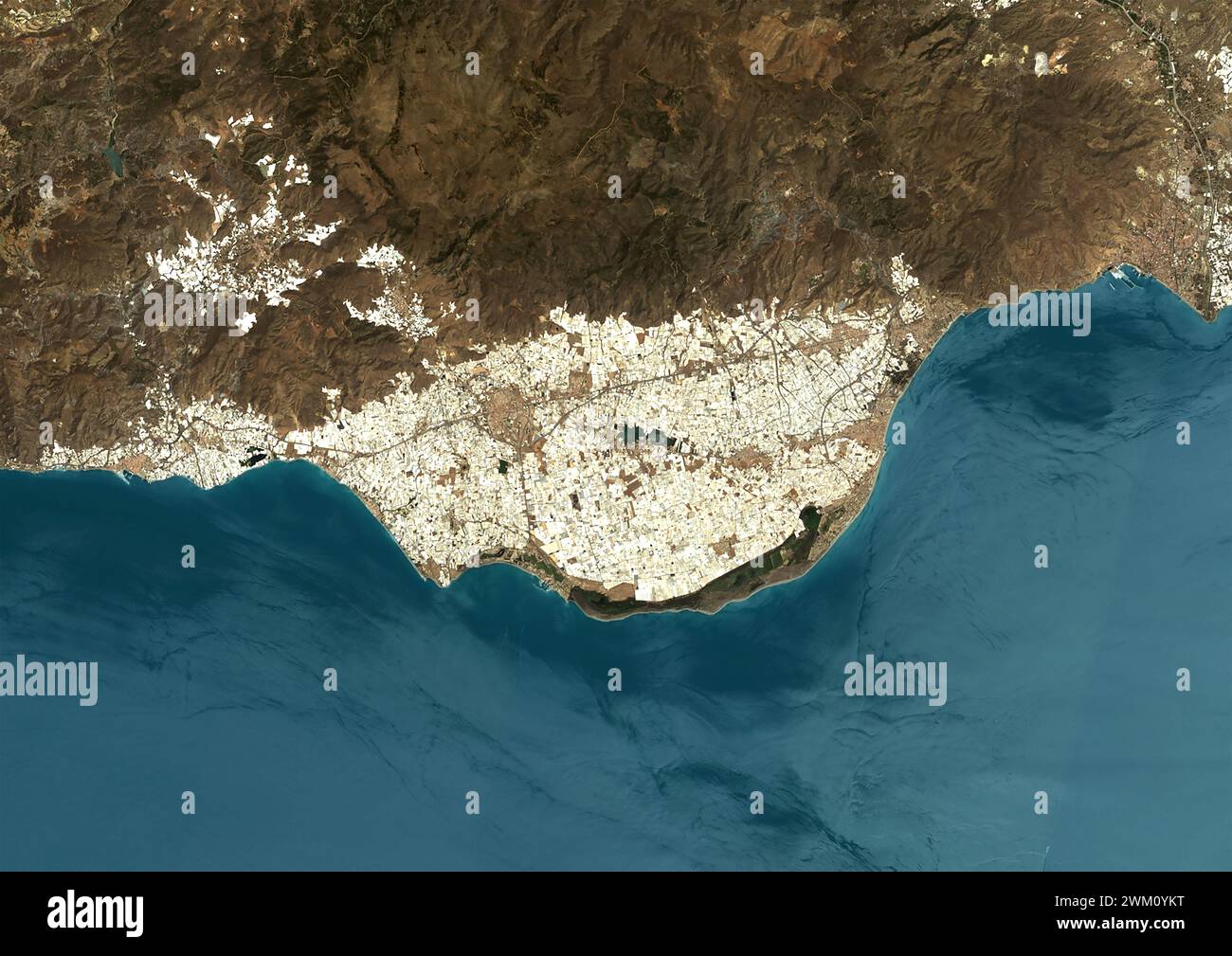 Color satellite image of intensive farming in Almeria, Spain in 2022. The image shows the 'plastic sea' formed by greenhouses. Stock Photo