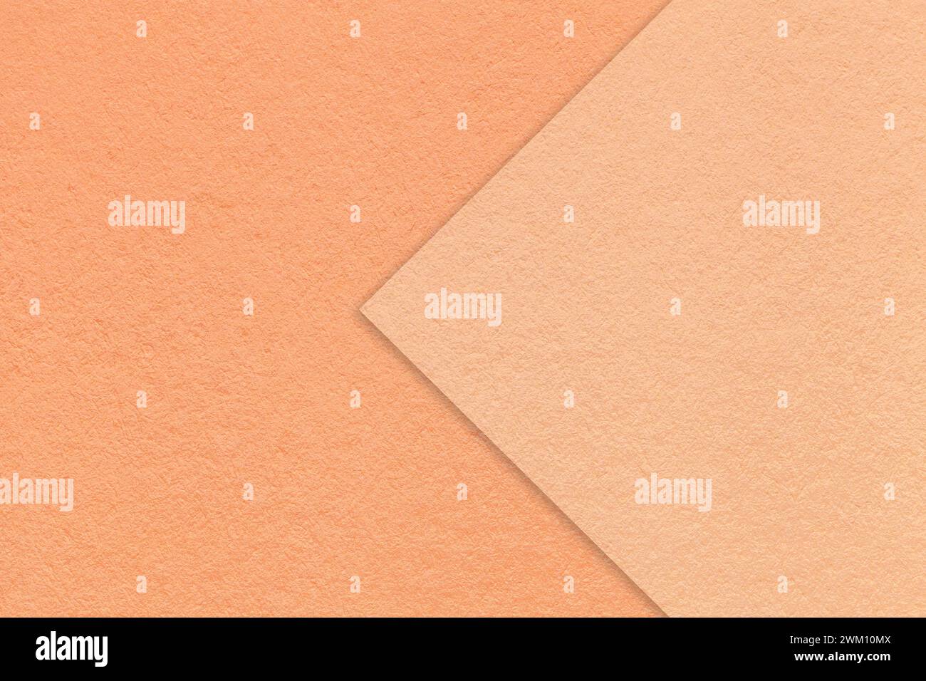 Color of the year 2024. Texture of coral paper background, half two colors with peach fuzz arrow, macro. Structure of dense craft cardboard. Felt abst Stock Photo