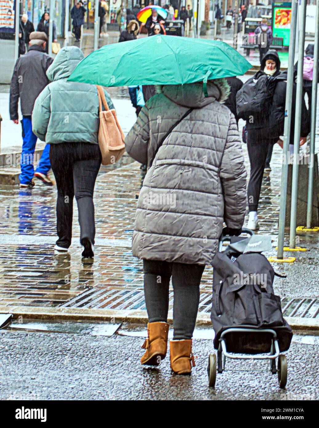 Glasgow, Scotland, UK. 23rd  February, 2024. UK Weather:  Heavy rain saw locals shelter under umbrellas on the style mile Sauchiehall street. Credit Gerard Ferry/Alamy Live News Stock Photo