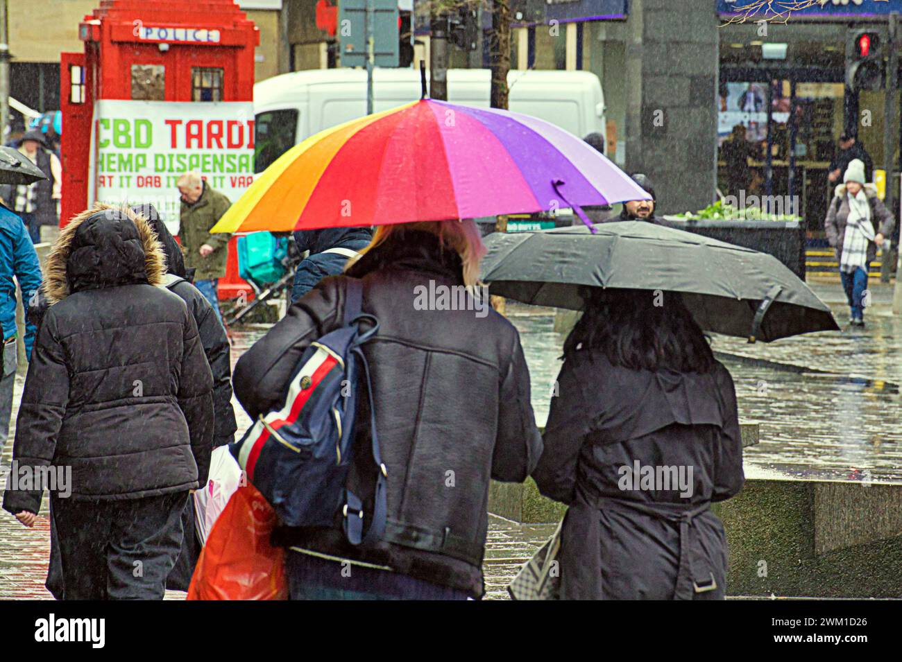 Glasgow, Scotland, UK. 23rd  February, 2024. UK Weather:  Heavy rain saw locals shelter under umbrellas on the style mile Sauchiehall street. Credit Gerard Ferry/Alamy Live News Stock Photo