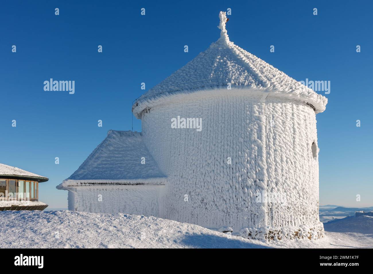 Winter morning , wooden Roman catholic chapel and disc shaped meteorological observatory in snezka, mountain on the border between Czech Republic and Stock Photo