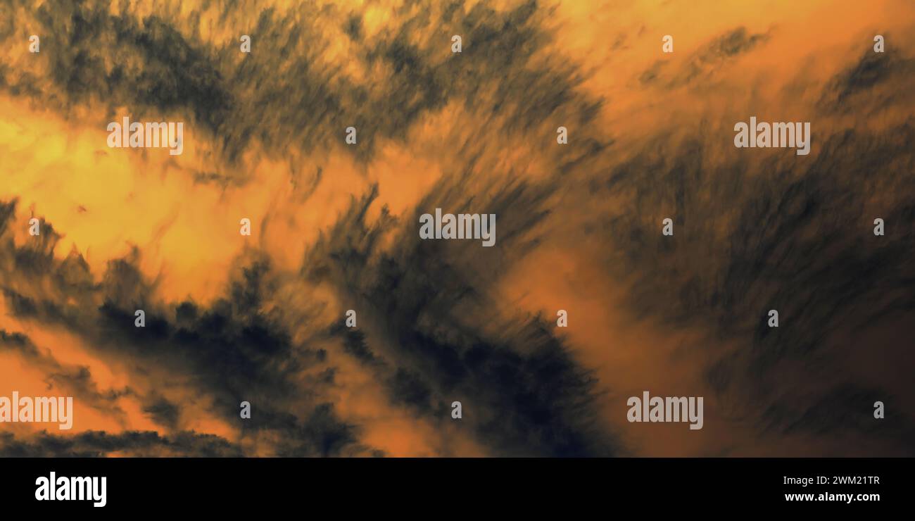 Golden sunset sky with dramatic dark clouds. Dark clouds contrasting a ...