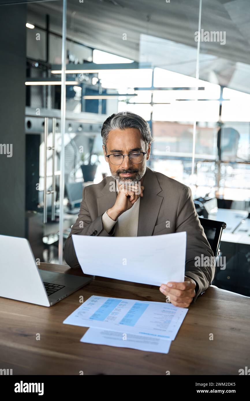 Busy mature professional business man manager checking documents at work. Stock Photo