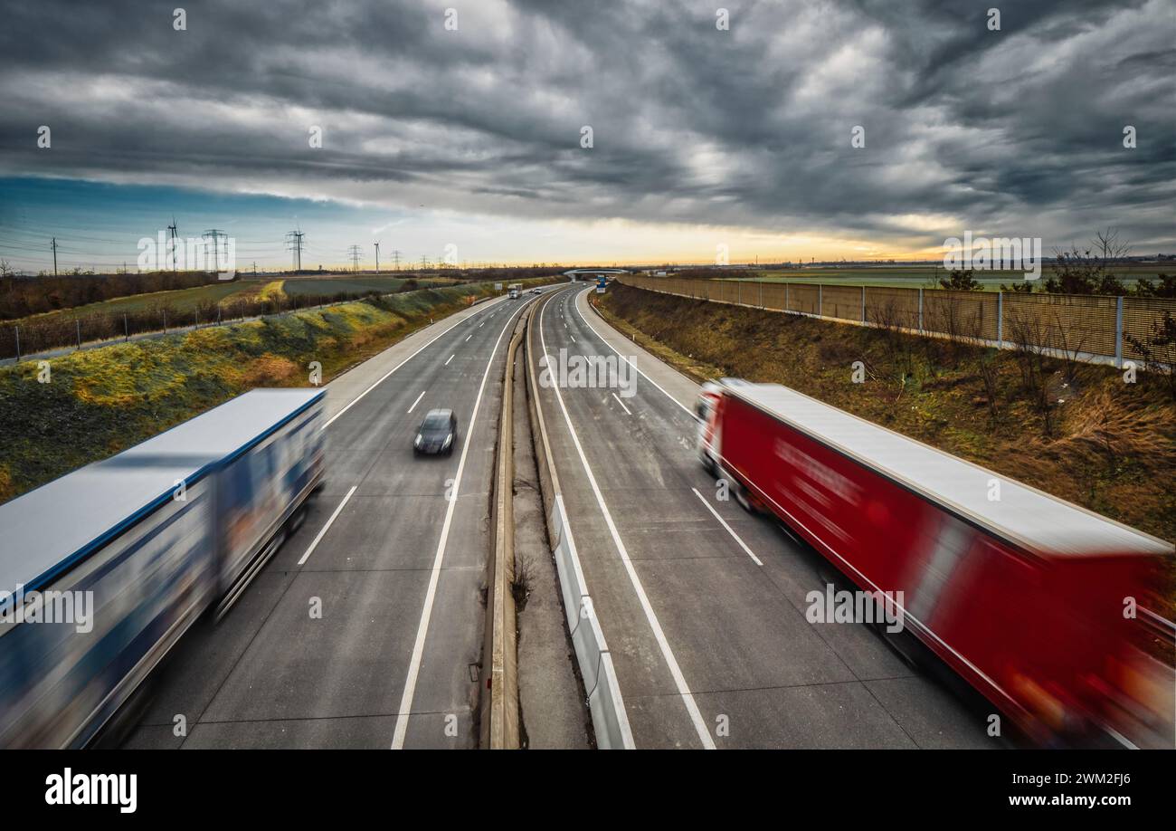 Autobahn in Österreich mit vorbeifahrenden LKW und PKW - bewölkter Himmel - intensive Farben Stock Photo