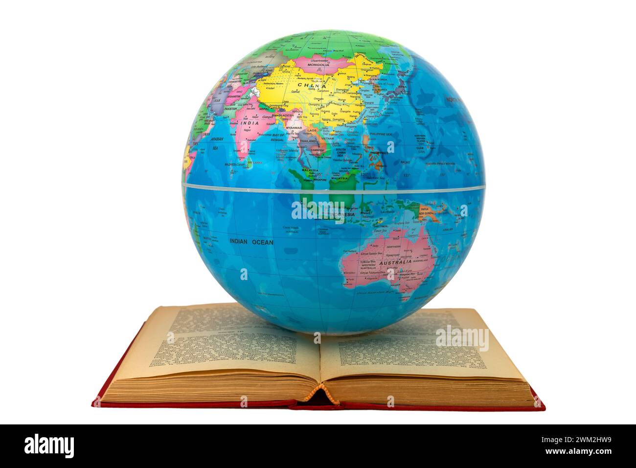 Earth globe on an open book showing Asia and Australia: study and learning concept. The open book symbolizes reading, study and global learning. Stock Photo