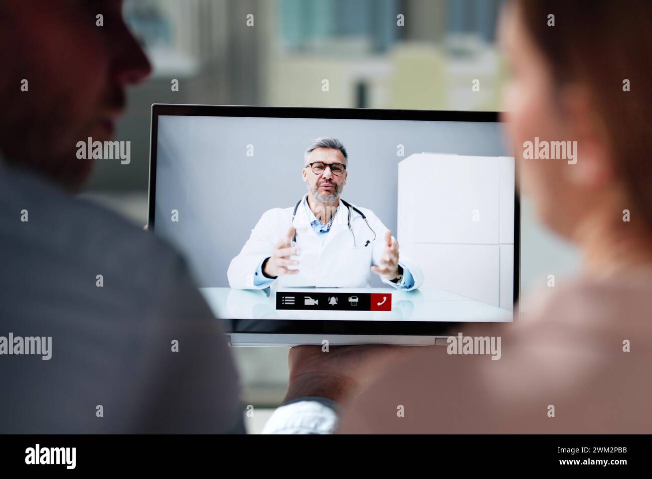 Pregnant Couple In Online Video Conference Call With Doctor Stock Photo