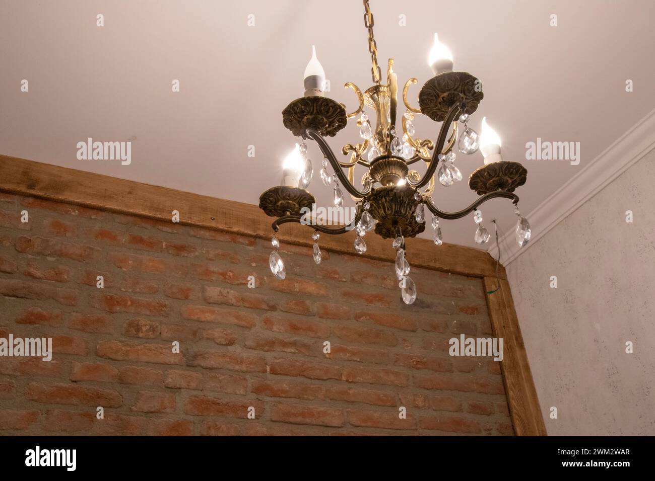 Antique chandelier against a vintage brick wall Stock Photo