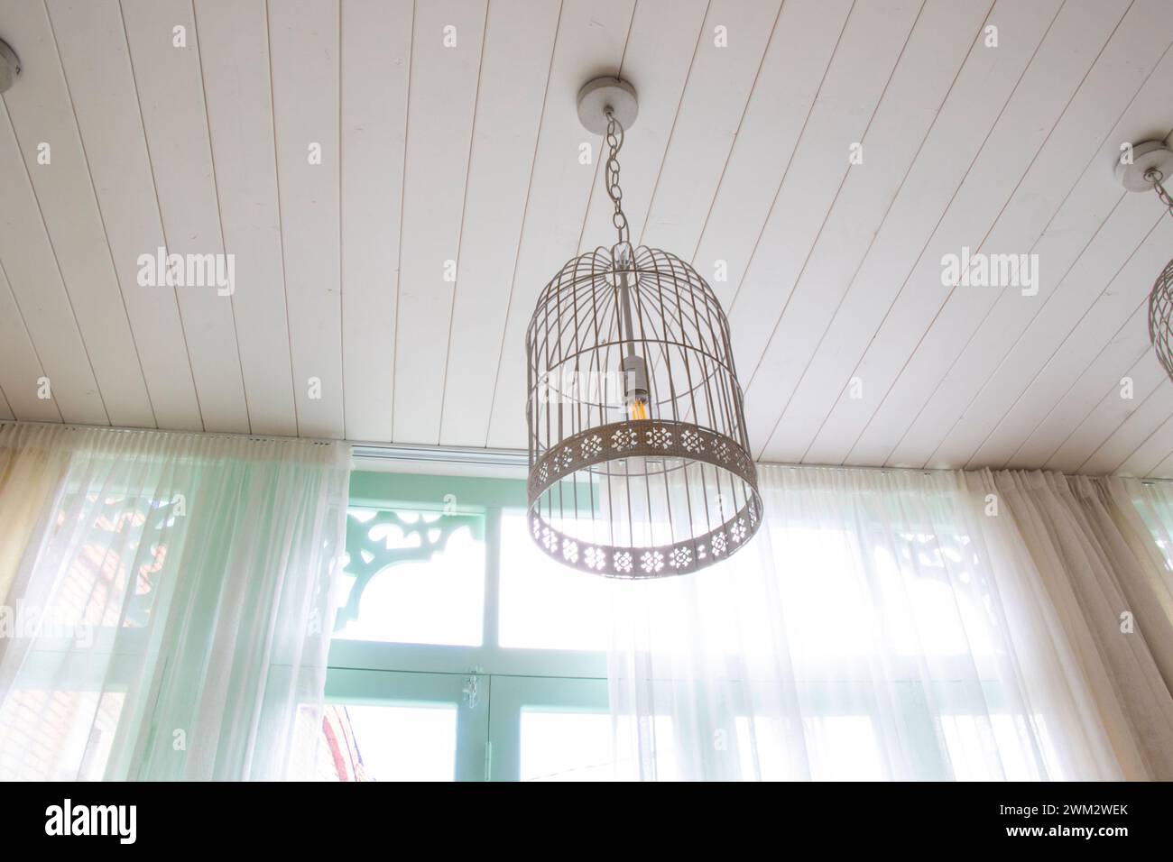 Three ceiling lights suspended by curtains Stock Photo