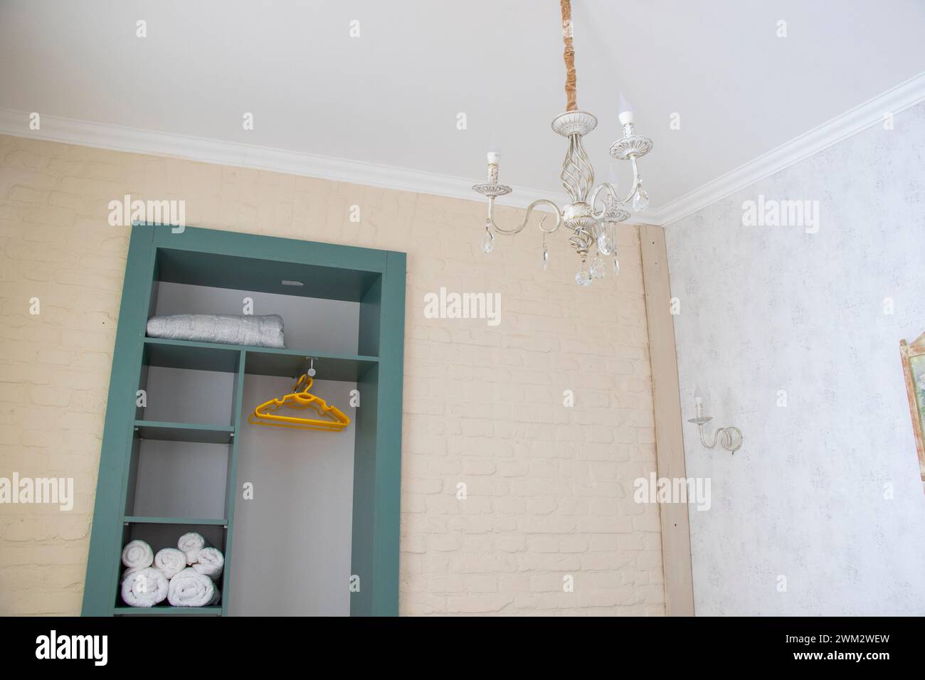 A compact bathroom featuring a wall-mounted light fixture Stock Photo