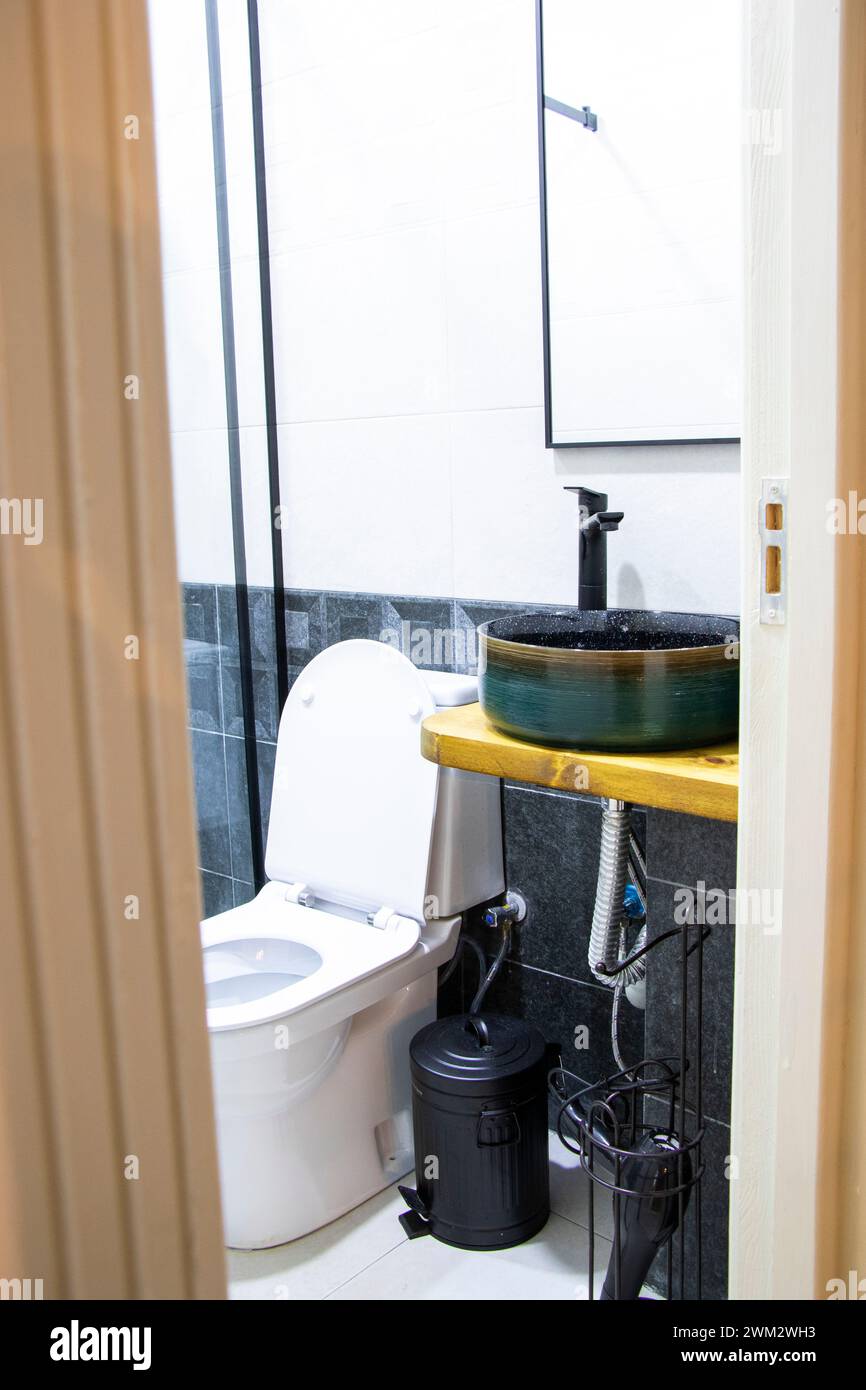 Bathroom with sink, toilet, and black and white tiles Stock Photo