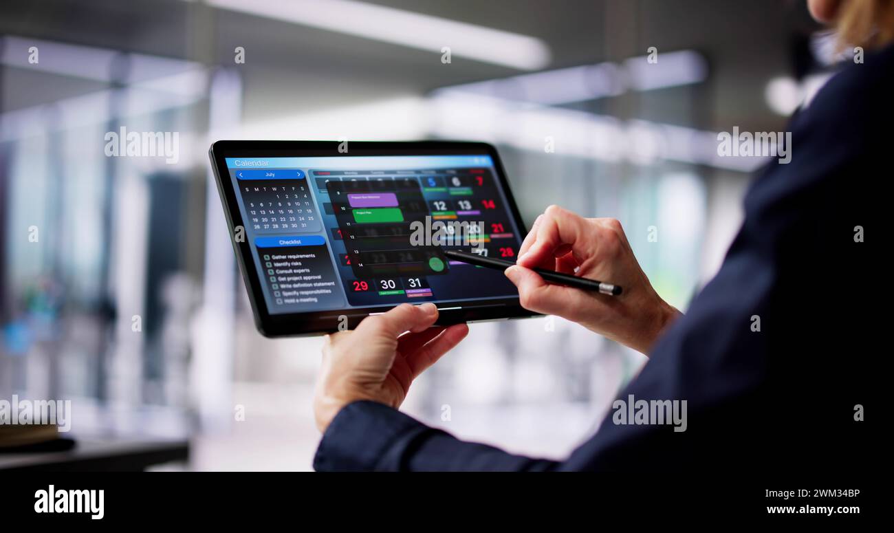 Executive Using Digital Calendar Agenda On Tablet Stock Photo