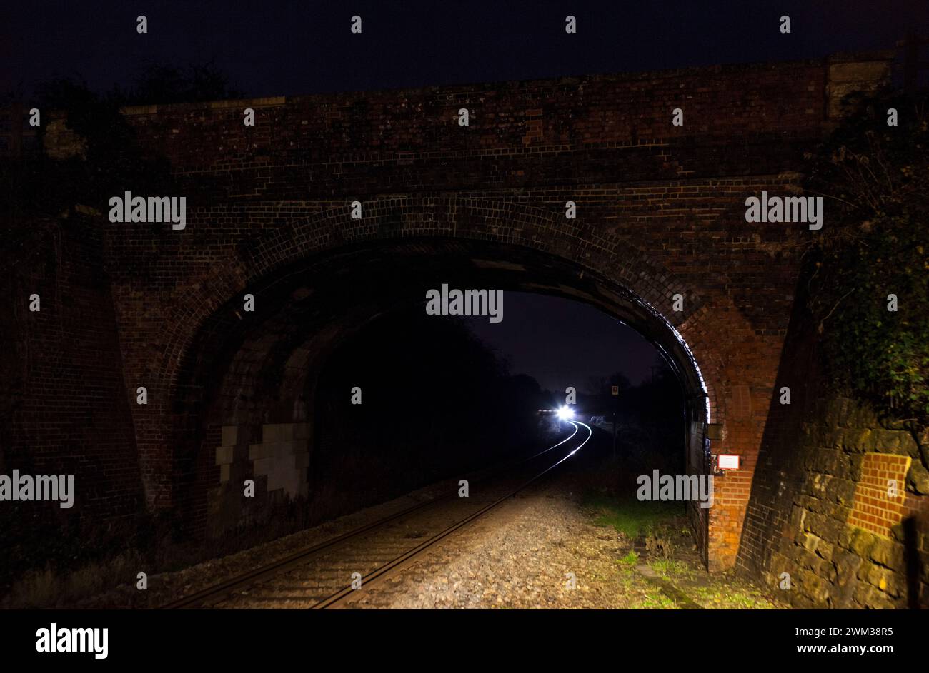 Train about to pass under a bridge at Finstock on the Cotswolds railway ...