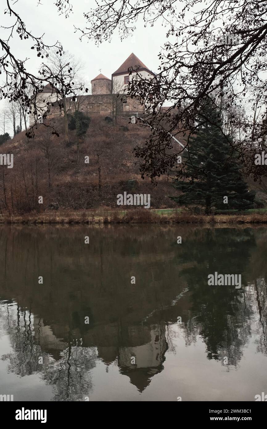 Landscape with a castle on the hill and a lake in front of it Stock Photo