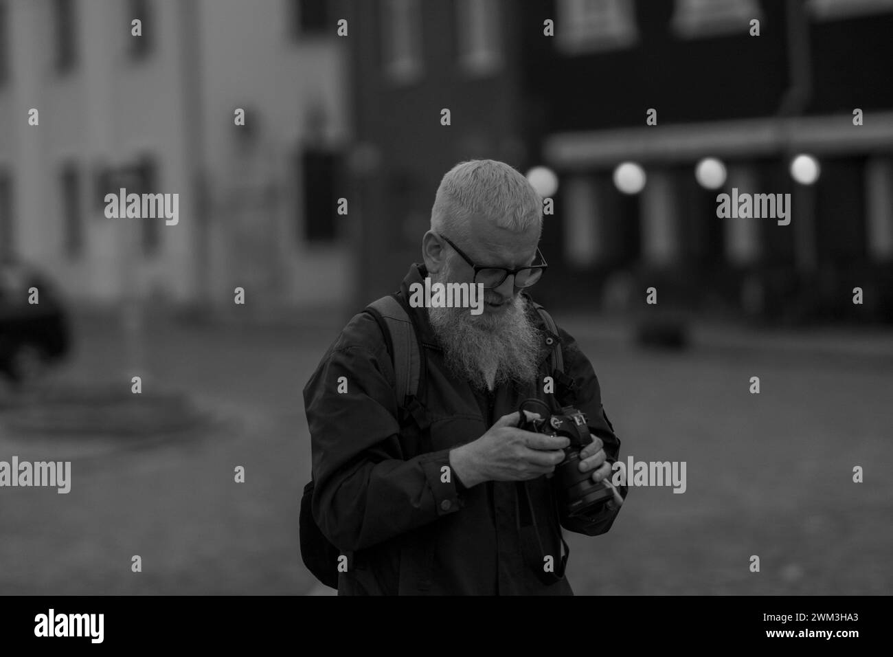 Black and white photo of Kaunas Old Town with a bearded man with a photo camera Stock Photo