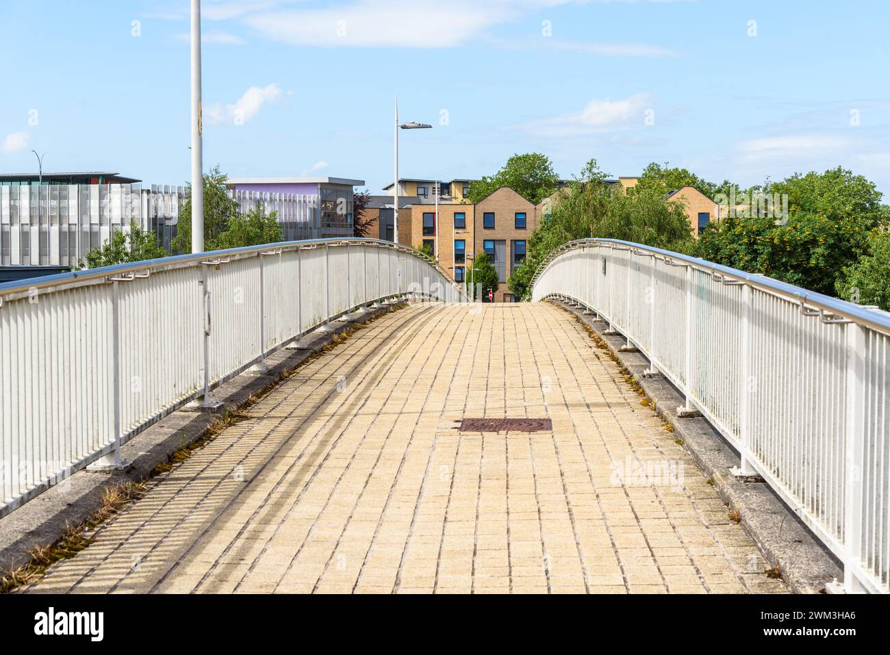 Deserted footbridge over a major thoroughfare leading to a residential district on a sunny summer day Stock Photo