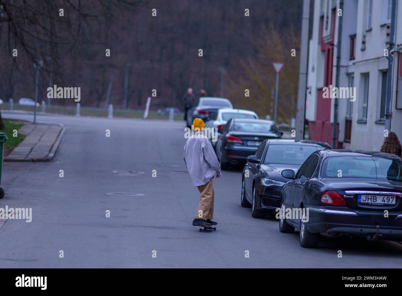 A young man with a skateboard in Kaunas Old Town Stock Photo