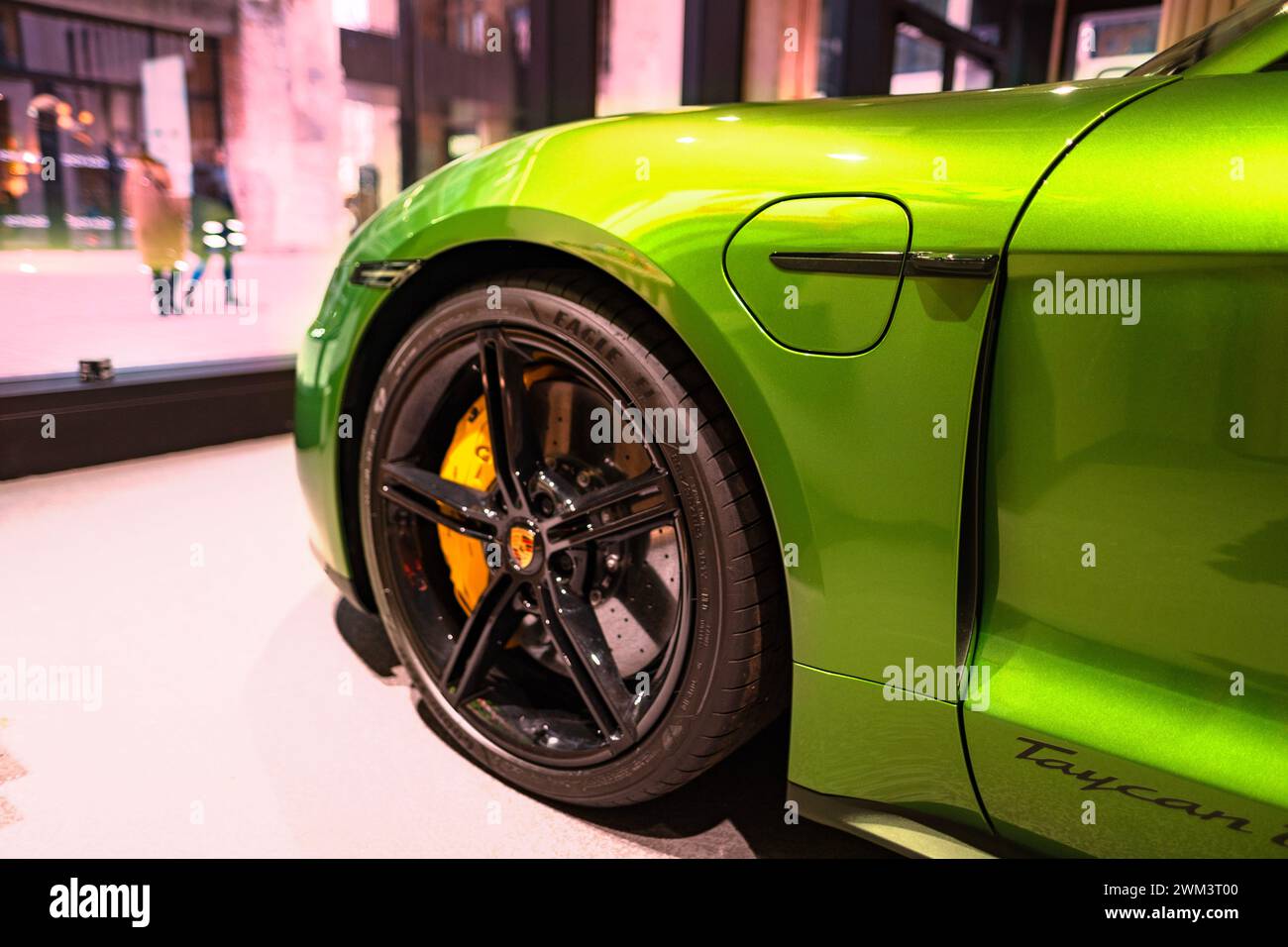 wheel of new green Porsche Taycan Turbo S battery-electric sports Car, sedan Porsche Automobil Holding in showroom, Innovation in automotive industry Stock Photo