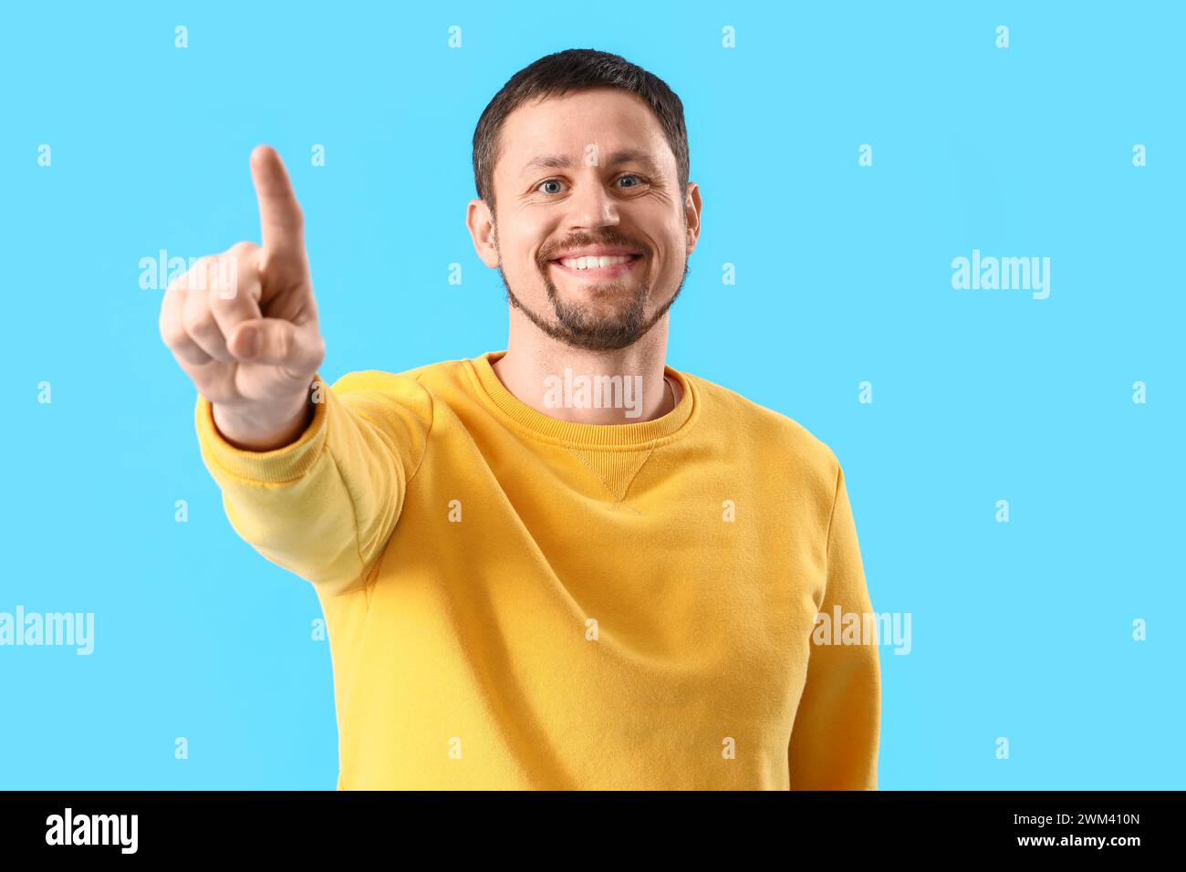 Handsome man using virtual screen on blue background Stock Photo