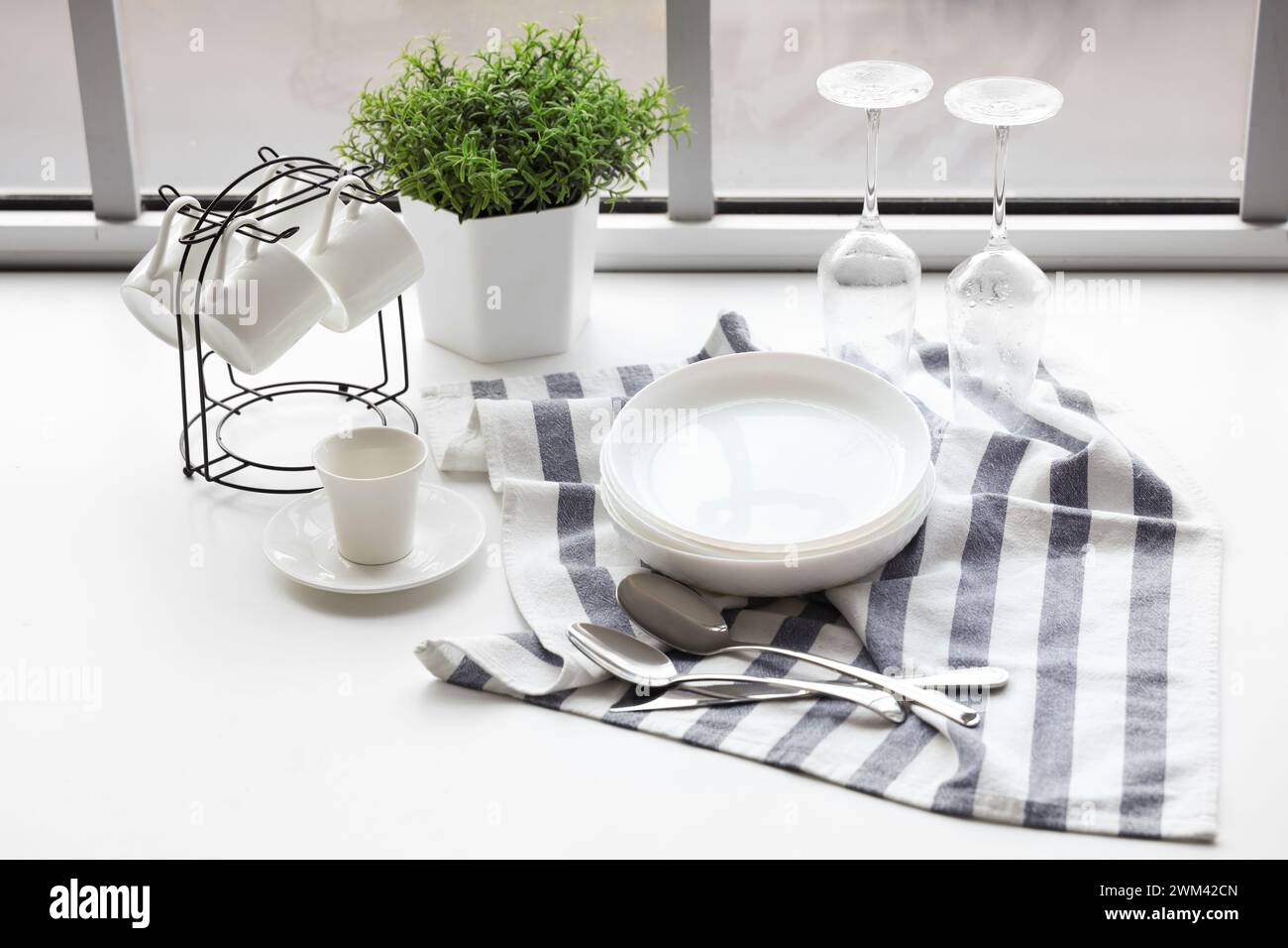 Set of clean dishes on table near window in kitchen Stock Photo - Alamy
