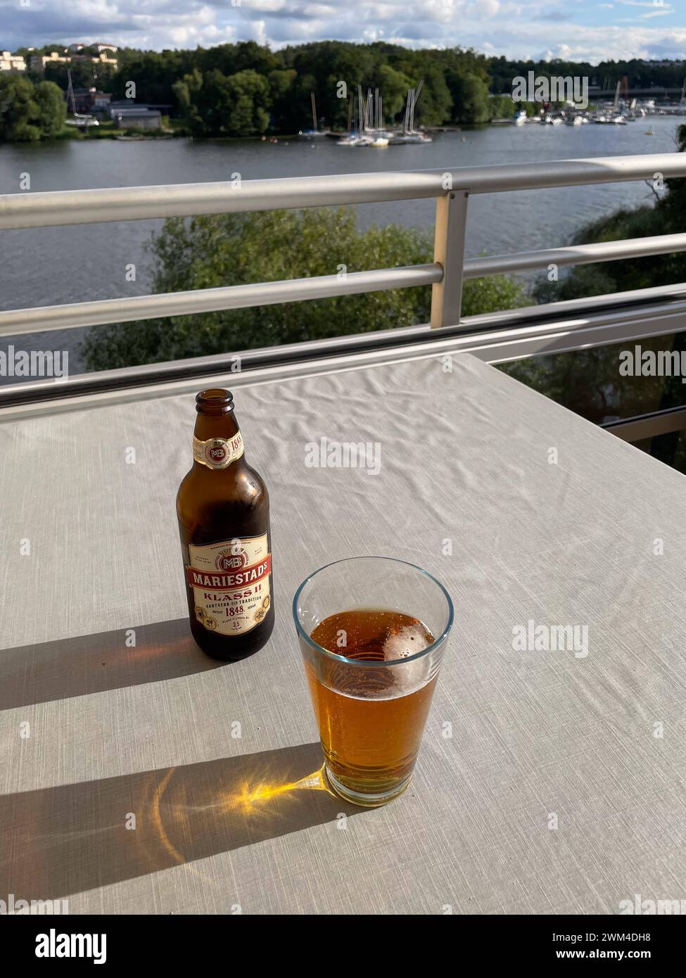 stockholm, sweden, 29 july 2023, mariestad beer , bottle and glass on a balcony *** stockholm, schweden, 29. juli 2023, mariestad bier, flasche und glas auf einem balkon Copyright: xx Stock Photo