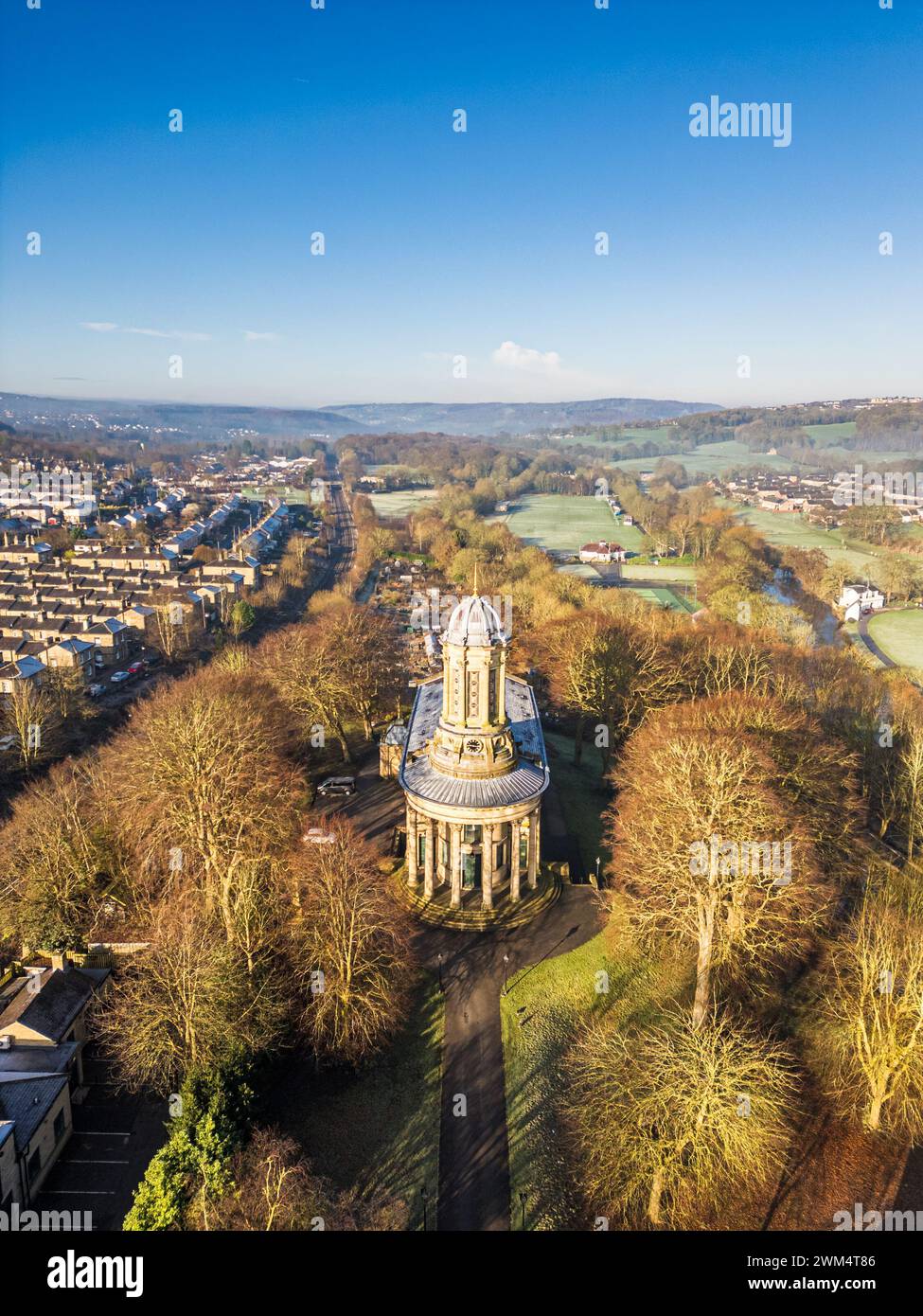 Aerial view of Saltaire United reformed church and Saltsire village a UNESCO World Heritage site in West Yorkshire. Blue sky vertical shot of Yorkshire village and church. Stock Photo
