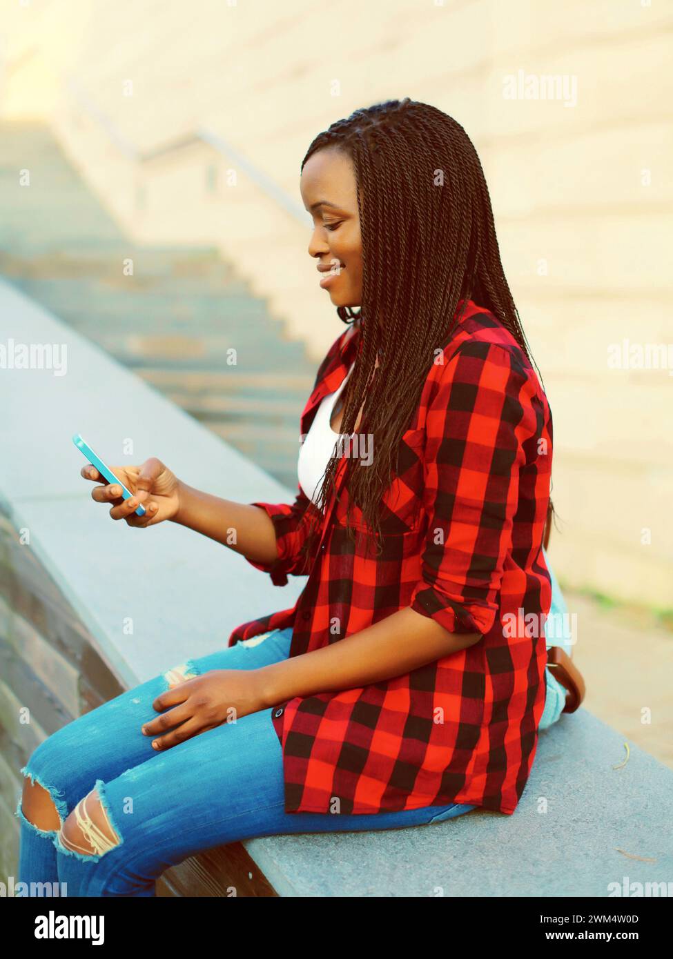 Happy young smiling african woman with smartphone student in the city ...