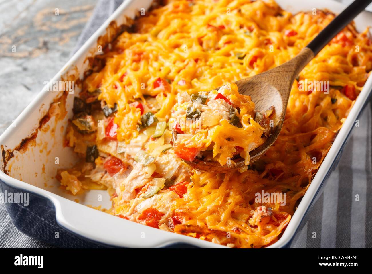 King Ranch Chicken Casserole is a Southern Texas staple dish close-up in a baking dish on a marble table. Horizontal Stock Photo