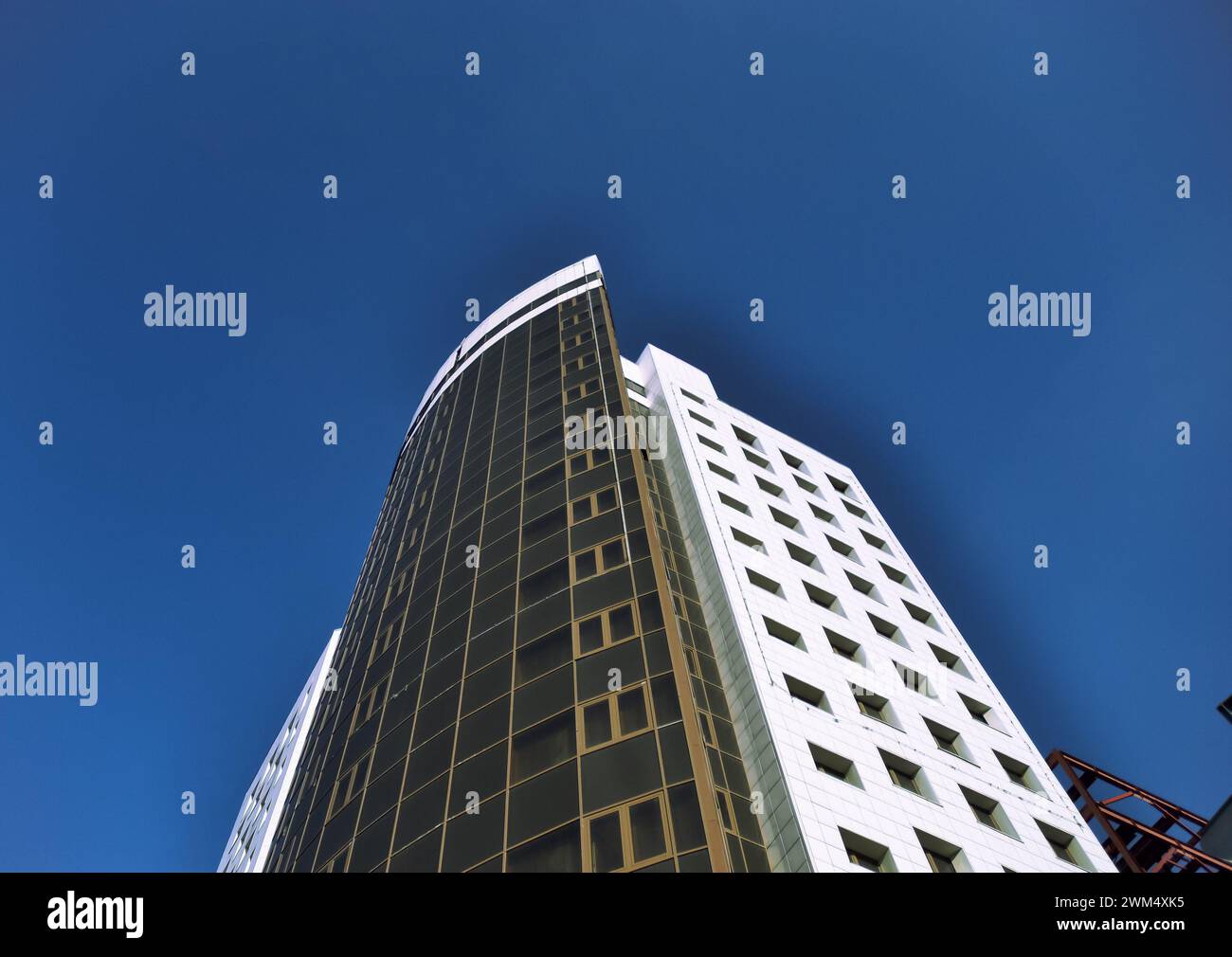 View from below of a white high-rise office building against a clear ...