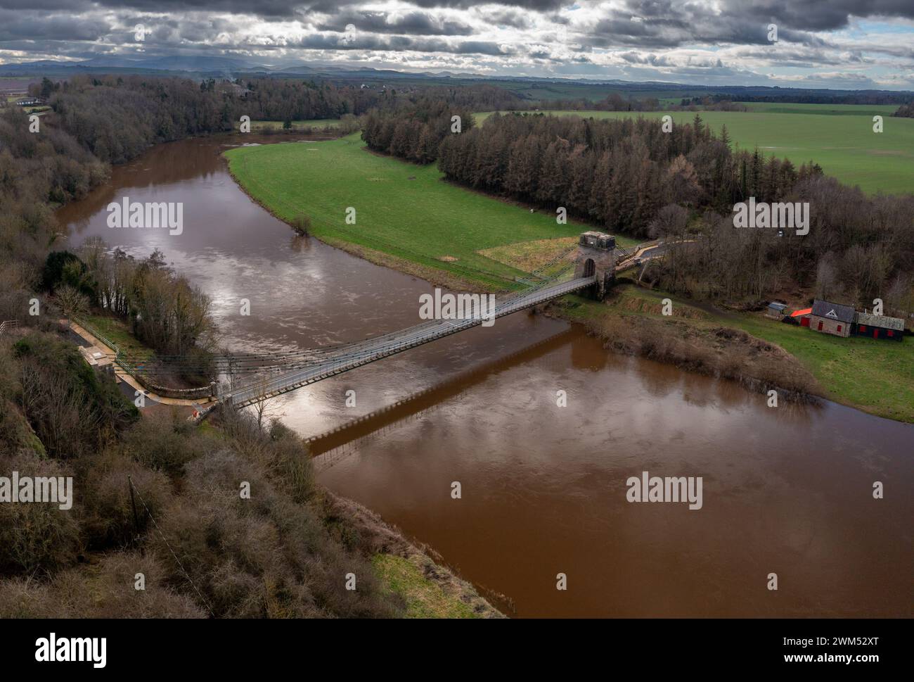 The Union Chain Bridge which has recently undergone a £10 million restoration, linking England and Scotland across the River Tweed which is in spate Stock Photo