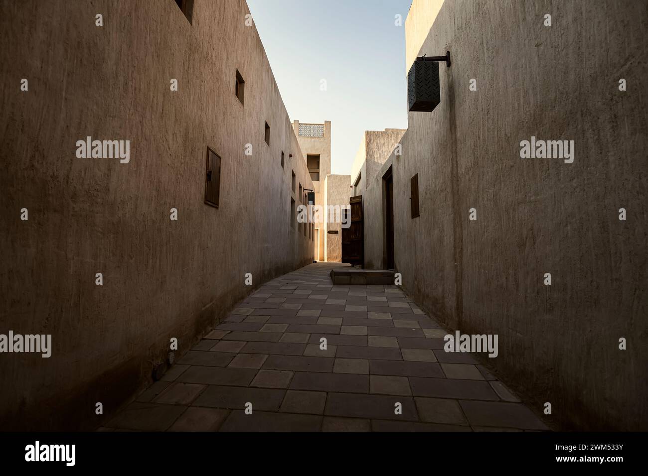Traditional Arabic streets in historical Al Fahidi district, Al Bastakiya. Dubai, United Arab Emirates. Old Dubaino people . Stock Photo