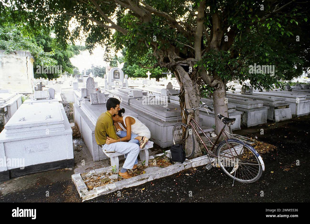 At the Cementerio Colon (Columbus Cemetery) in Havana, a couple mourns the loss of their relatives. Stock Photo