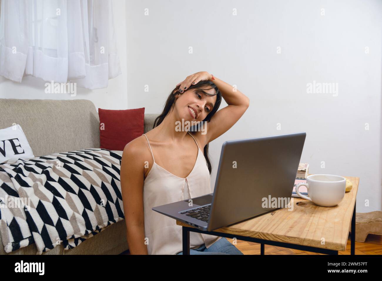 young Latina entrepreneur woman at home with laptop sitting working ...