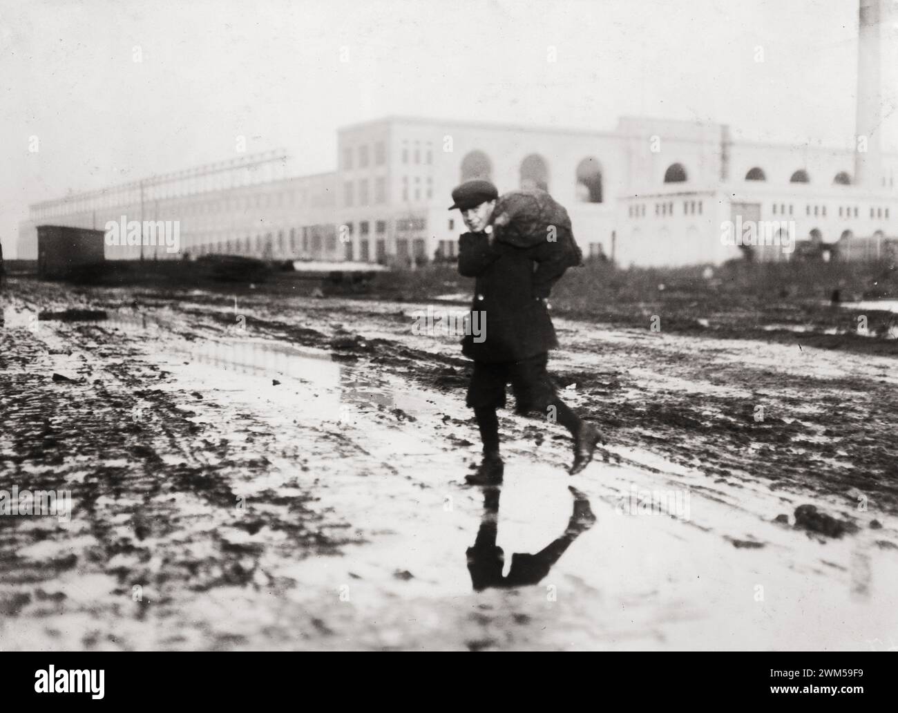 A Boy Stealing coal from railroad coal-yard. Boston, Massachusetts. Photo by Lewis W. Hine. Stock Photo