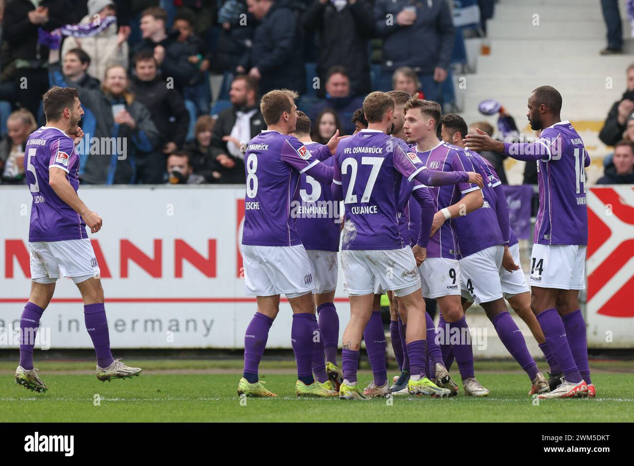 24 February 2024, Lower Saxony, Osnabrück: Soccer: Bundesliga 2, VfL Osnabrück - Hannover 96, matchday 23 at the Stadion an der Bremer Brücke. Osnabrück's goalscorer Erik Engelhardt (3rd from right) celebrates his goal for 1:0 with Bashkim Ajdini (l-r), Robert Tesche, Florian Kleinhansl, Michael Cuisance, Maxwell Gyamfi and Oumar Diakhite. Photo: Friso Gentsch/dpa - IMPORTANT NOTE: In accordance with the regulations of the DFL German Football League and the DFB German Football Association, it is prohibited to utilize or have utilized photographs taken in the stadium and/or of the match in the Stock Photo