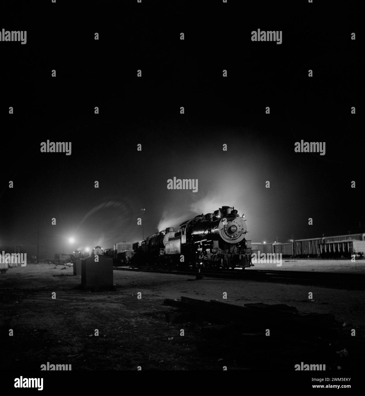 Train with locomotive in the dark - Barstow, California. A view of the Atchison, Topeka and Santa Fe Railroad yard at night - Jack Delano photo, 1943 Stock Photo
