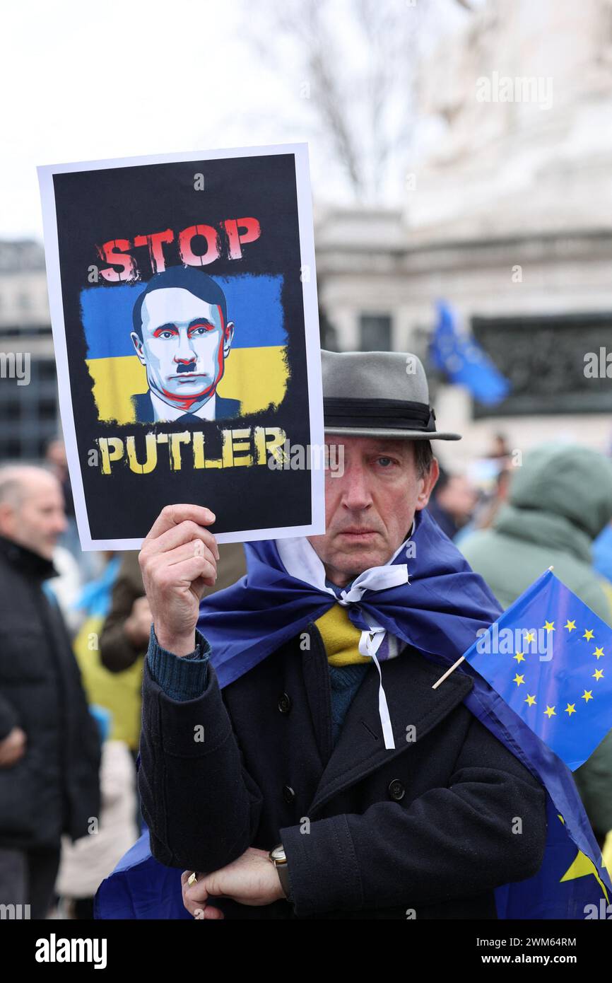 Paris, France. 24th Feb, 2024. Portrait of a demonstrator holding a sign with the message Stop Putler in reference to Adolf Hitler, during the demonstration. Demonstration against the Russian military invasion of Ukraine and in support of the Ukrainian people, on the Republic square, on febuary 24, 2024 in Paris. Photo by Christophe Michel/ABACAPRESS.COM Credit: Abaca Press/Alamy Live News Stock Photo