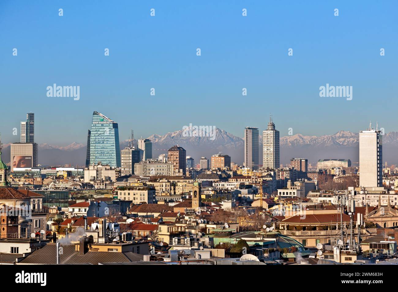 Skyline of Milan city with the Alps Mountains at the background, as seen from the rooftop of the Duomo, the Cathedral of Milan, in Italy, Europe. Stock Photo