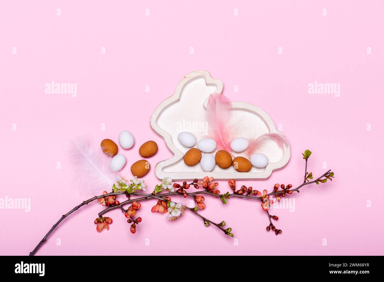 Eier und Zweige mit Frühlingsblüten vor  einem pinken Hintergrund Stock Photo