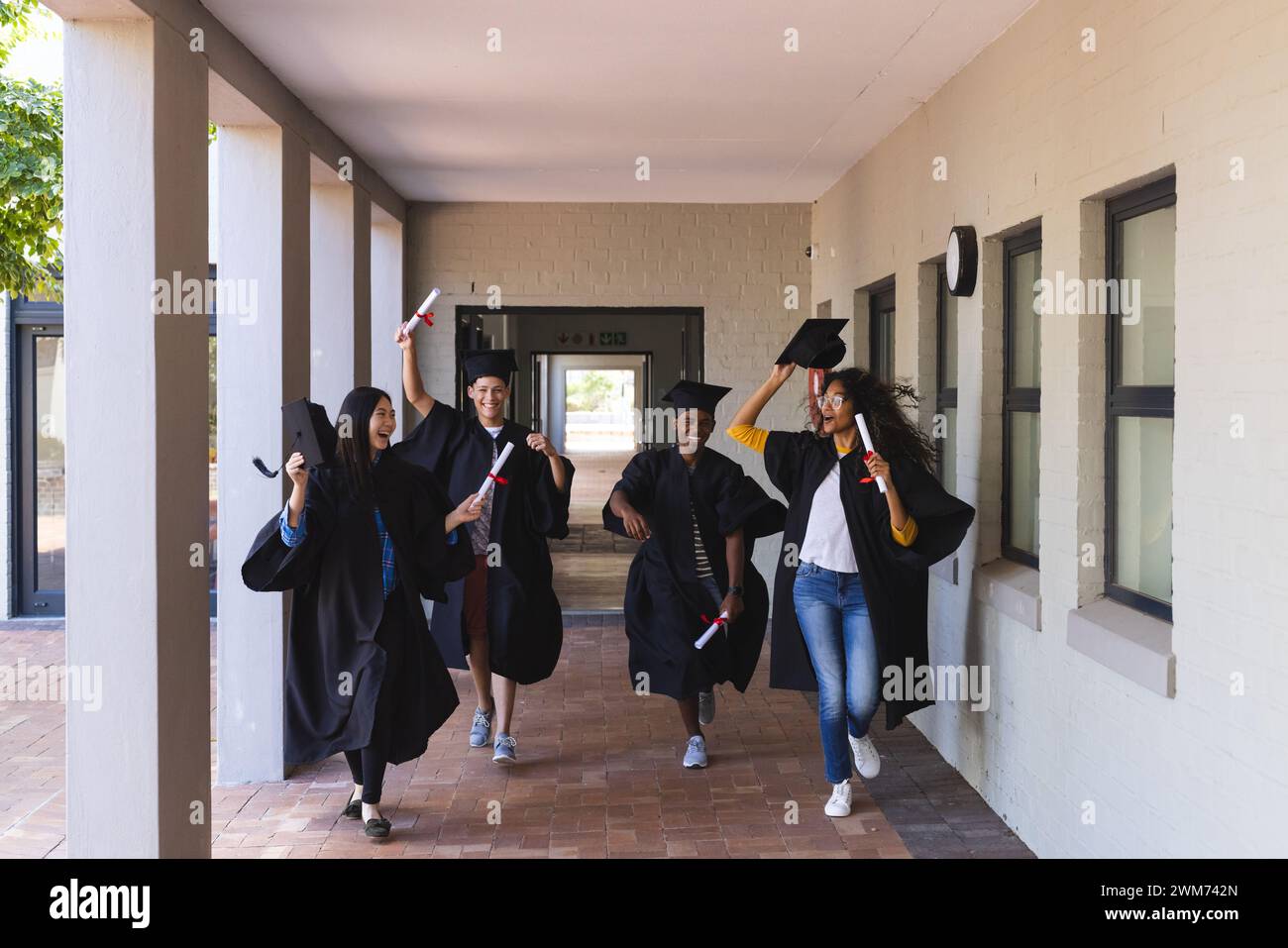 Diverse students celebrate graduation at high school Stock Photo