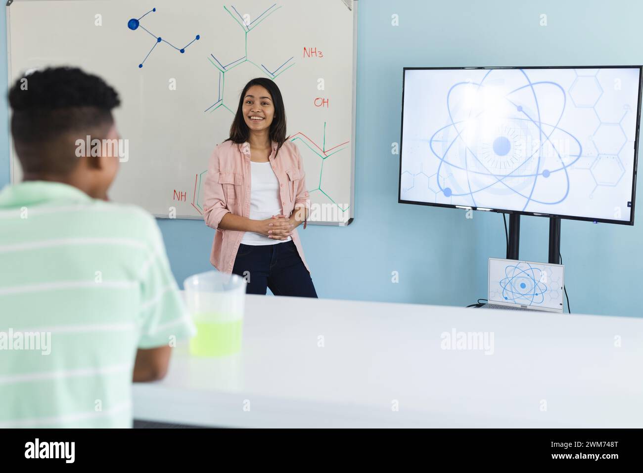 Young biracial teacher teaches in a high school science classroom Stock Photo